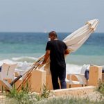 Un empleado de un restaurante protegido con mascarilla en la playa de El Saler. / FOTO: Kai Försterling (EFE).