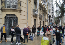 Centenares de personas hacen cola en el reparto de alimentos de la calle Colón.