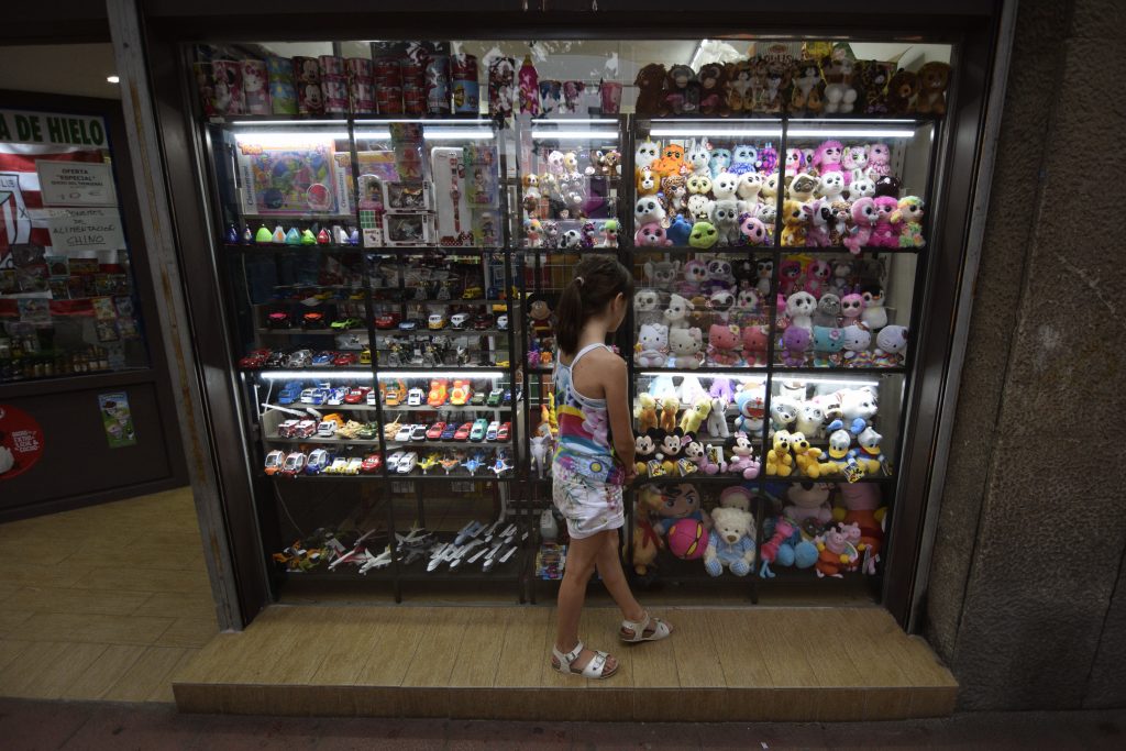 Niña mirando juguetes en un escaparate