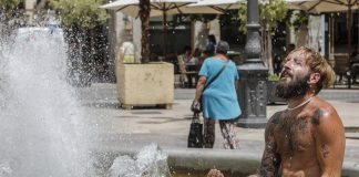 Un hombre se refresca en una fuente del centro de Valencia. / ROBER SOLSONA (EUROPA PRESS)