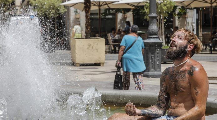 Un hombre se refresca en una fuente del centro de Valencia. / ROBER SOLSONA (EUROPA PRESS)