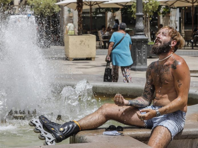 Un hombre se refresca en una fuente del centro de Valencia. / ROBER SOLSONA (EUROPA PRESS)