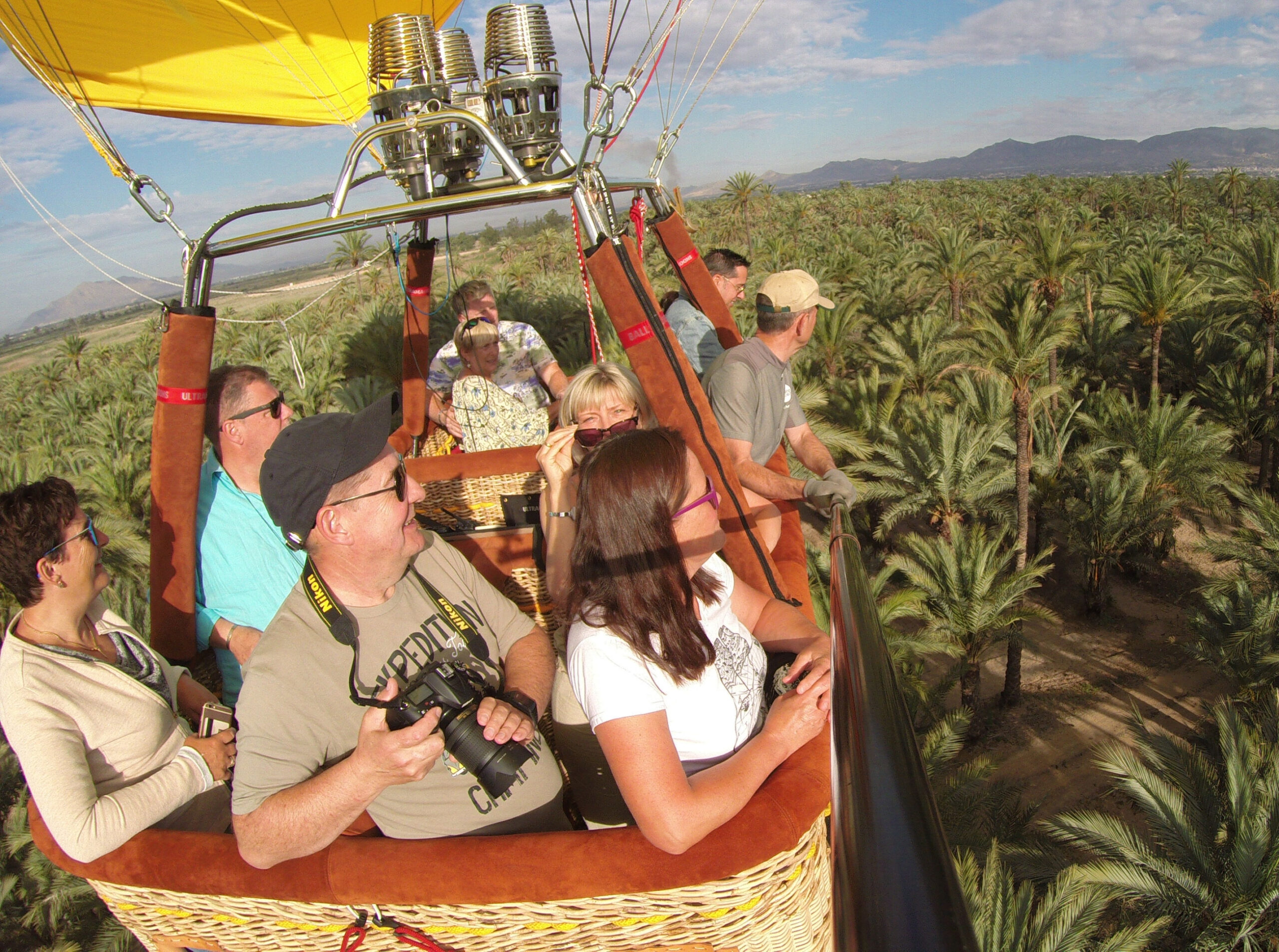 Un grupo de turistas vuela sobre uno de los palmerales de la ciudad