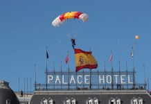Una paracaidista valenciana despliega la bandera en el desfile del 12 de octubre