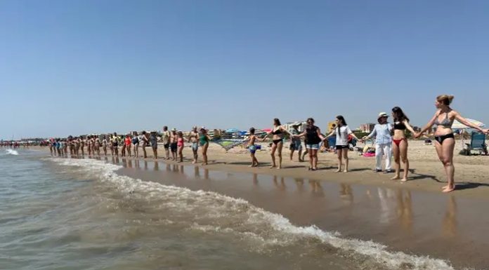 Una cadena humana en la Malvarrosa en protesta por el deterioro de la costa