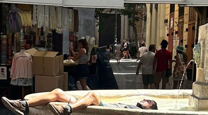 Un joven se baña en la fuente de la plaza Redonda