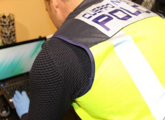 Agente de la Policía Nacional inspeccionando un ordenador por estafa