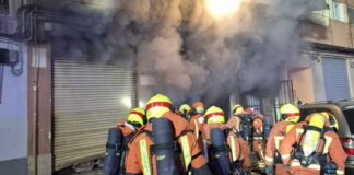 Bomberos accediendo al local afectado por el incendio de Quart de Poblet