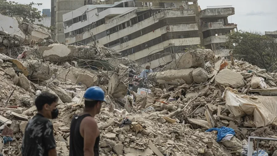 Dos personas entre los escombros de un edificio de Venezuela