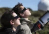 Eclipse solar: Cómo ver este espectáculo espacial sin dañar la vista Dos personas mirando un eclipse con gafas homologadas