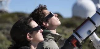 Dos personas mirando un eclipse con gafas homologadas