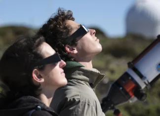 Dos personas mirando un eclipse con gafas homologadas