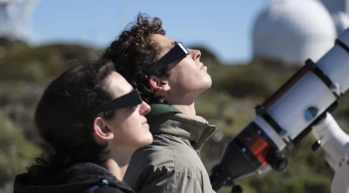 Dos personas mirando un eclipse con gafas homologadas