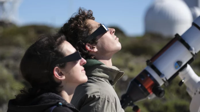 7televalencia eclipse solar ver Dos personas mirando un eclipse con gafas homologadas