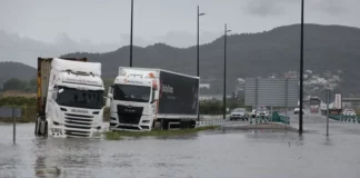 Varios camiones atrapados en una zona inundada en la N332, a las afueras de Gandía, este lunes. EFE/Manuel Bruque
