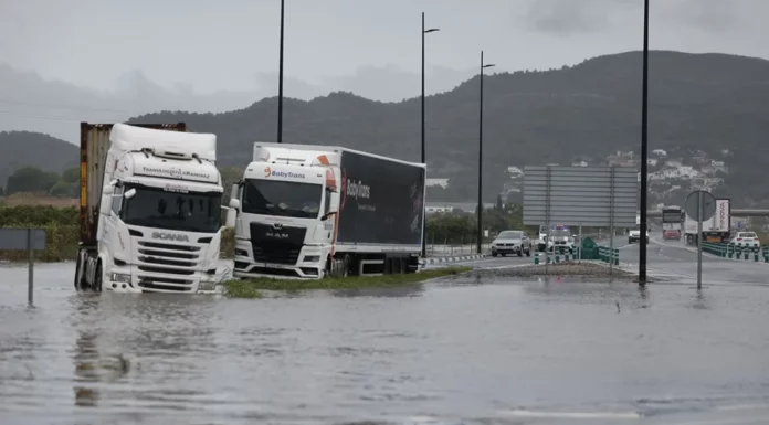 Varios camiones atrapados en una zona inundada en la N332, a las afueras de Gandía, este lunes. EFE/Manuel Bruque