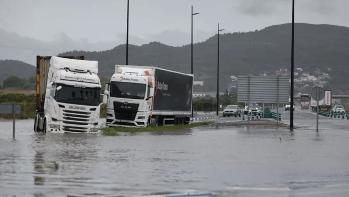 7televalencia dana-adam-valencia Varios camiones atrapados en una zona inundada en la N332, a las afueras de Gandía, este lunes. EFE/Manuel Bruque