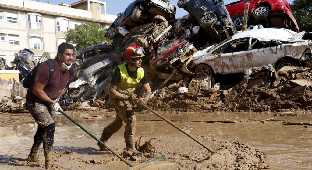 Voluntarios y vecinos despejan una de las calles de Alfafar. / MIGUEL ÁNGEL POLO (EFE)